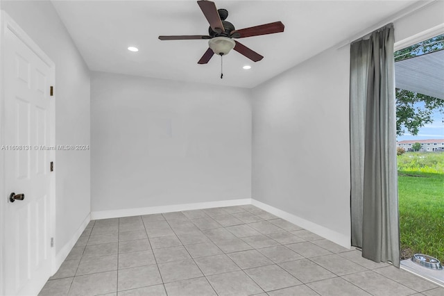 tiled empty room featuring ceiling fan