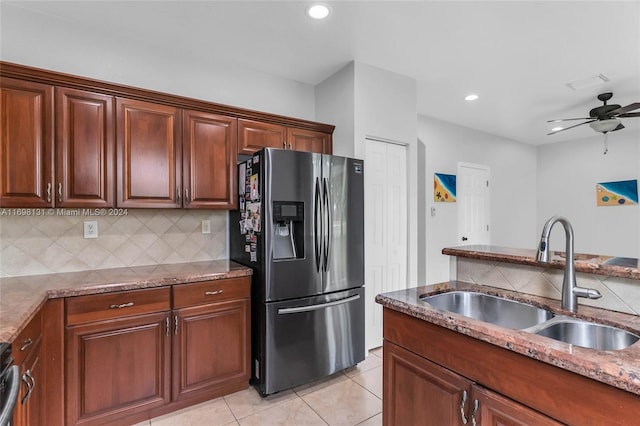 kitchen with ceiling fan, sink, light stone countertops, stainless steel fridge, and light tile patterned floors