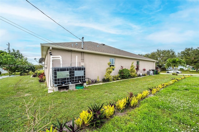 view of property exterior featuring central air condition unit and a yard