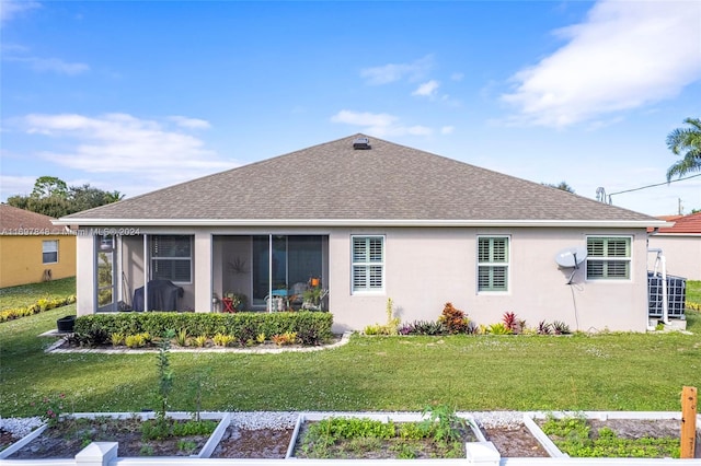 back of house featuring a lawn and a sunroom