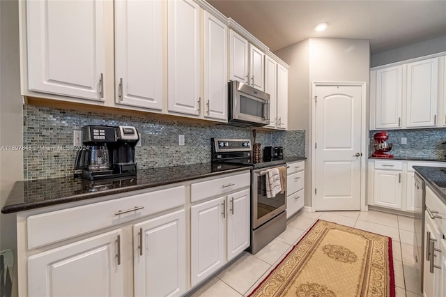 kitchen with appliances with stainless steel finishes, tasteful backsplash, white cabinetry, and light tile patterned flooring