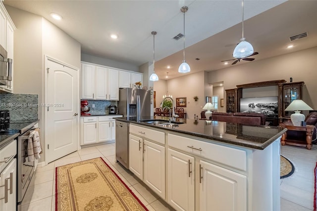 kitchen featuring a center island with sink, sink, appliances with stainless steel finishes, tasteful backsplash, and white cabinetry