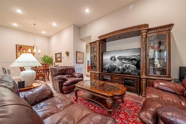 living room with a towering ceiling and a chandelier