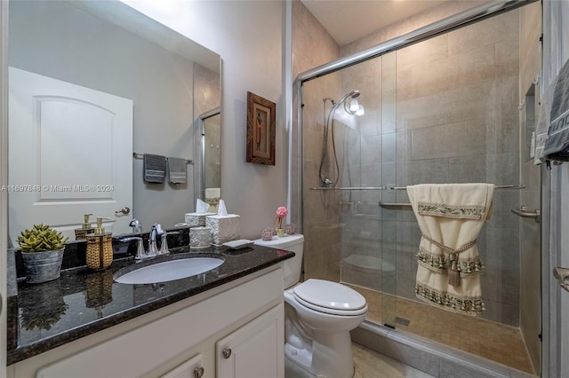 bathroom featuring a shower with door, vanity, and toilet