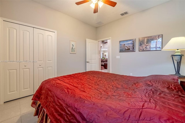 bedroom with ceiling fan, light tile patterned floors, and a closet