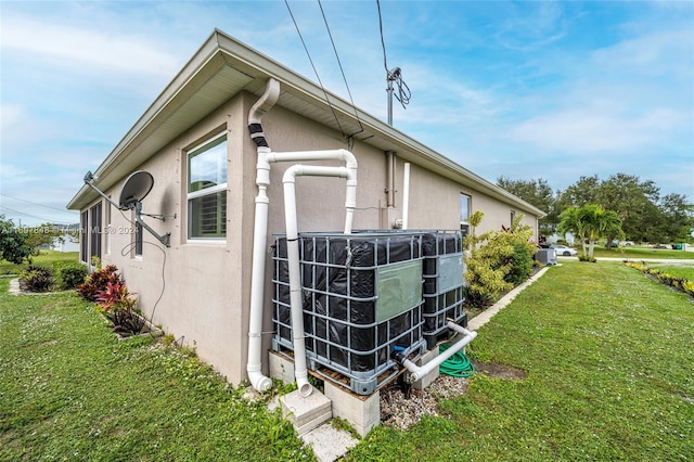 view of side of property featuring a yard and cooling unit