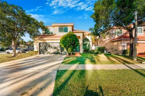 mediterranean / spanish house featuring a front yard and a garage