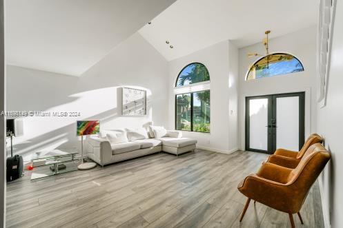 interior space featuring french doors, light wood-type flooring, and high vaulted ceiling