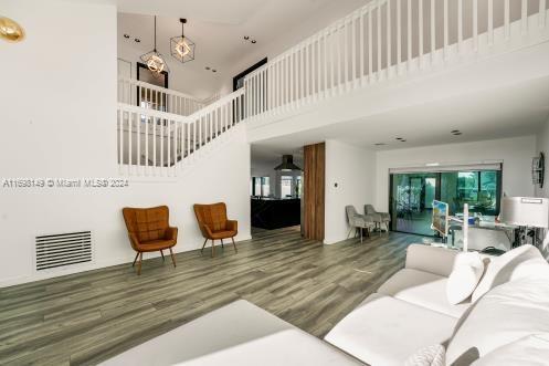 living room featuring hardwood / wood-style floors, a healthy amount of sunlight, and a high ceiling