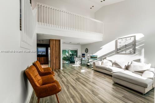 living room with hardwood / wood-style flooring and high vaulted ceiling