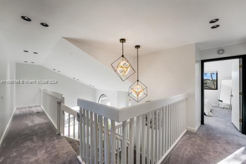 hall with dark colored carpet