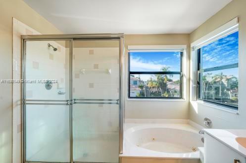 bathroom featuring shower with separate bathtub and vanity