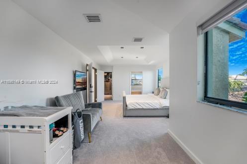 carpeted bedroom featuring multiple windows