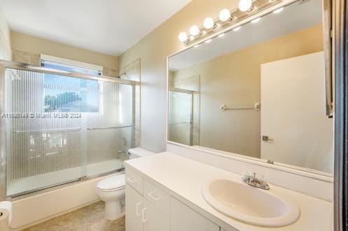 full bathroom featuring vanity, toilet, and combined bath / shower with glass door