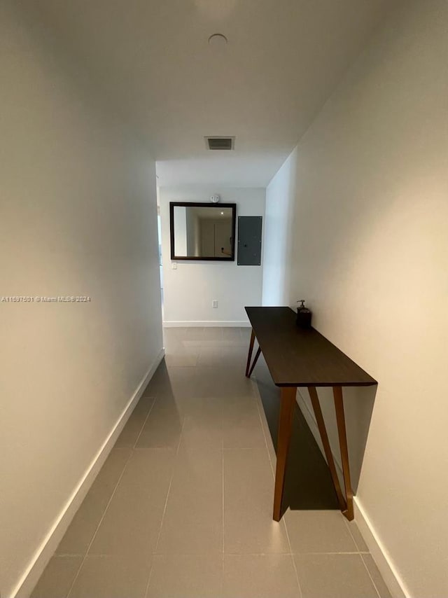 corridor featuring electric panel and tile patterned floors