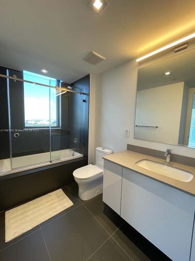 full bathroom with tile patterned floors, toilet, vanity, and combined bath / shower with glass door