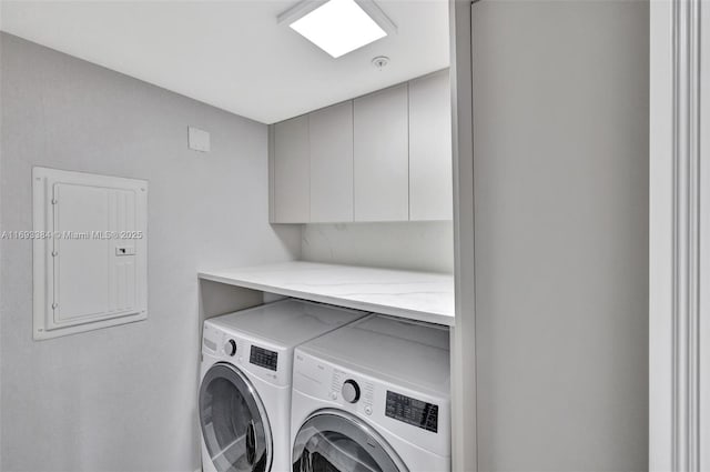 clothes washing area with cabinets, electric panel, and washing machine and clothes dryer