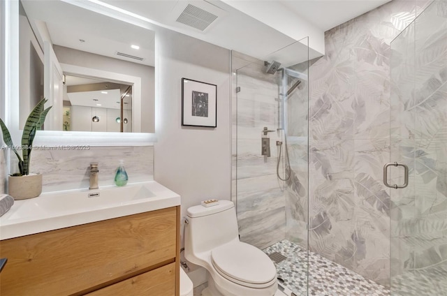 bathroom featuring vanity, an enclosed shower, and toilet