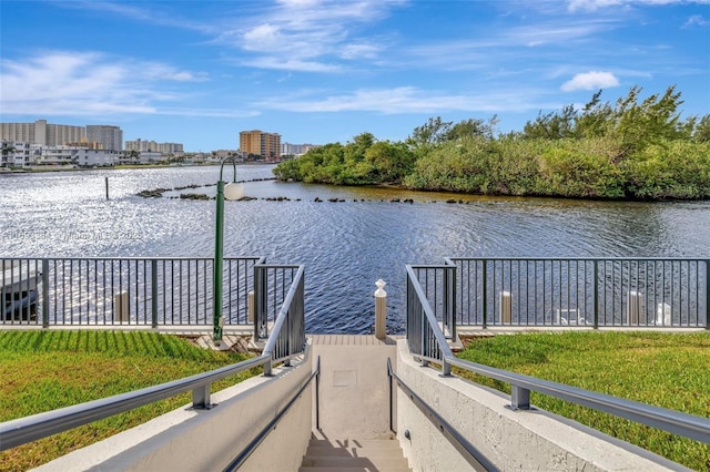 dock area with a water view and a yard