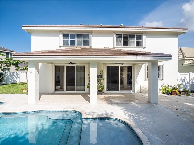 rear view of property with a fenced in pool, a patio area, and ceiling fan