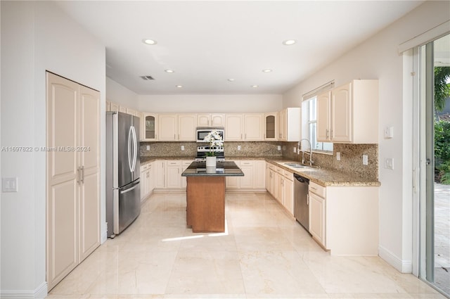 kitchen with a wealth of natural light, a center island, sink, and appliances with stainless steel finishes