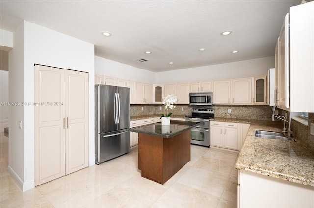 kitchen featuring decorative backsplash, a center island, sink, and stainless steel appliances