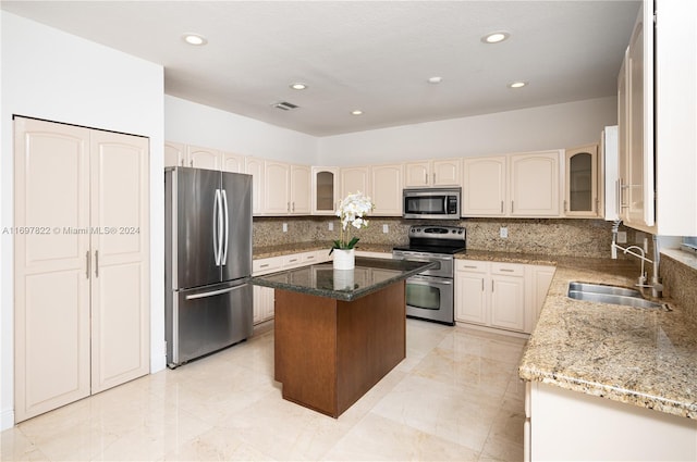 kitchen with tasteful backsplash, sink, a kitchen island, and stainless steel appliances