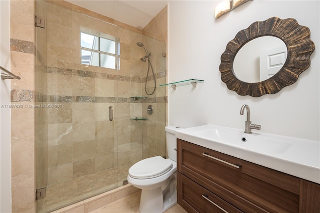 bathroom featuring tile patterned floors, vanity, toilet, and a shower with door