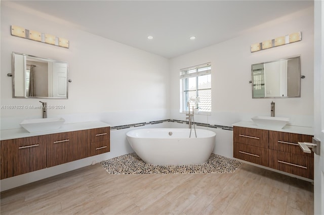 bathroom featuring a bathing tub, vanity, and wood-type flooring