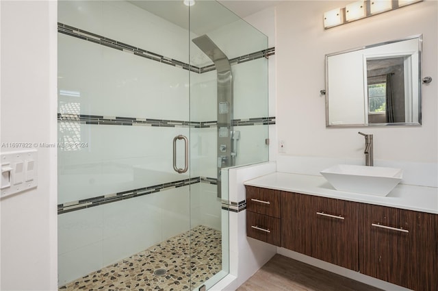 bathroom with hardwood / wood-style flooring, vanity, and walk in shower