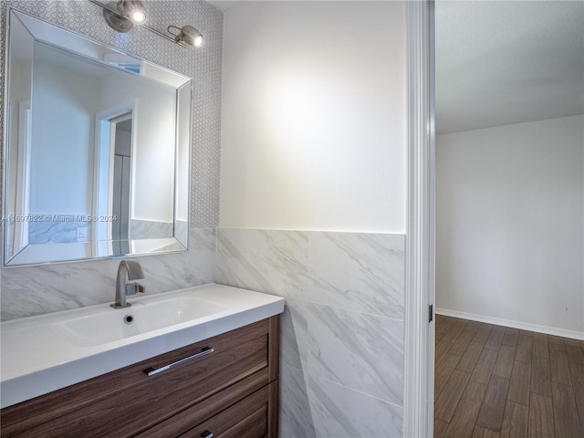 bathroom featuring vanity, wood-type flooring, and tile walls