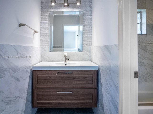 bathroom featuring vanity and tile walls