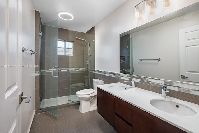 bathroom featuring walk in shower, vanity, tile walls, and toilet