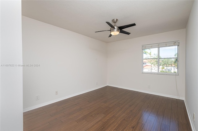 empty room with a textured ceiling, ceiling fan, and dark hardwood / wood-style floors