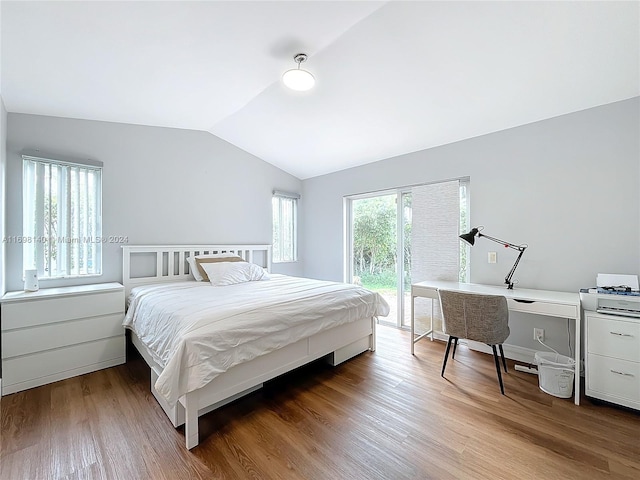 bedroom with access to exterior, hardwood / wood-style floors, and lofted ceiling