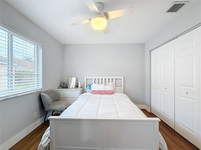 bedroom featuring ceiling fan, a closet, and dark wood-type flooring