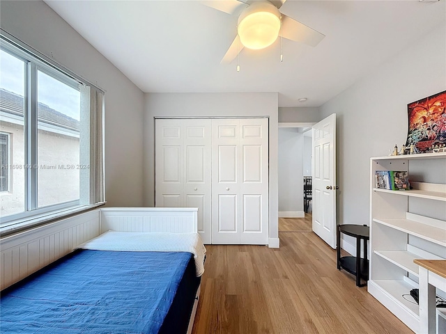 bedroom with light wood-type flooring, a closet, and ceiling fan