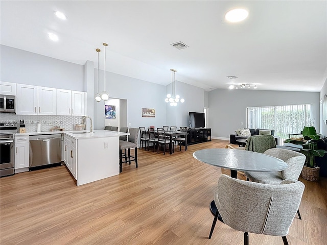 kitchen featuring white cabinetry, sink, stainless steel appliances, and light hardwood / wood-style flooring