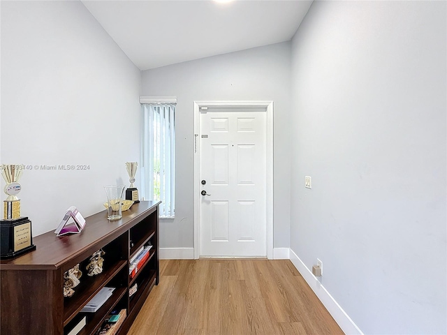 interior space with light wood-type flooring and vaulted ceiling