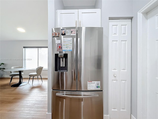 kitchen with white cabinets, stainless steel refrigerator with ice dispenser, and light hardwood / wood-style floors