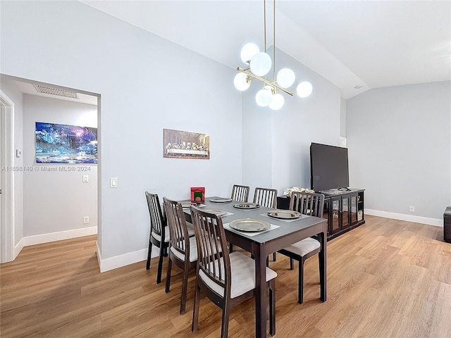 dining space with an inviting chandelier, light hardwood / wood-style flooring, and vaulted ceiling