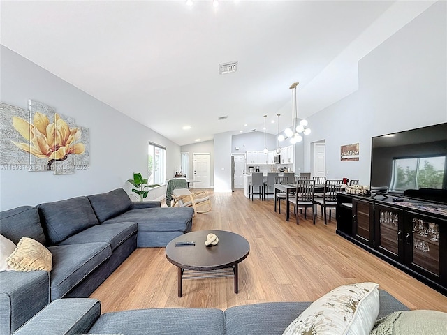 living room featuring light hardwood / wood-style flooring and vaulted ceiling