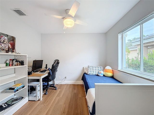 bedroom with multiple windows, ceiling fan, and light hardwood / wood-style flooring