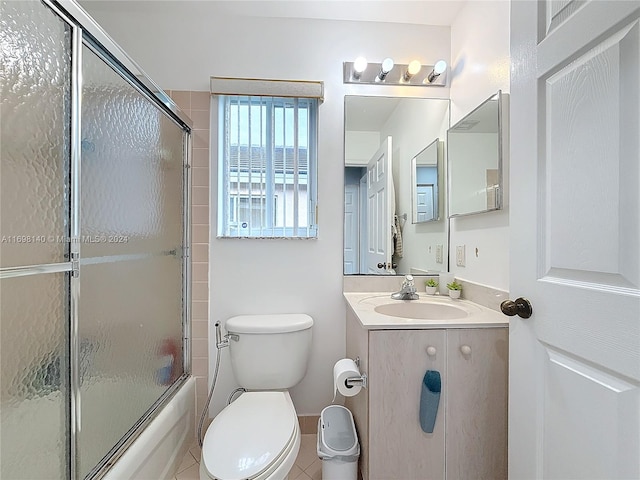 full bathroom with tile patterned flooring, vanity, combined bath / shower with glass door, and toilet