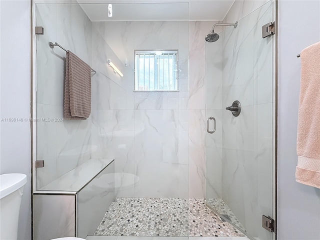 bathroom with toilet and a shower with door