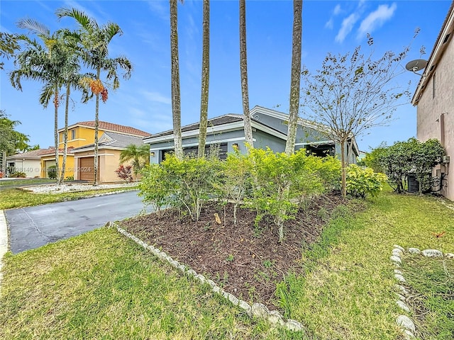 view of front facade featuring a garage, a front yard, and central AC