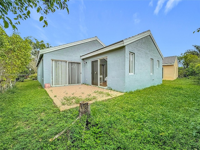 back of house with a patio area and a lawn