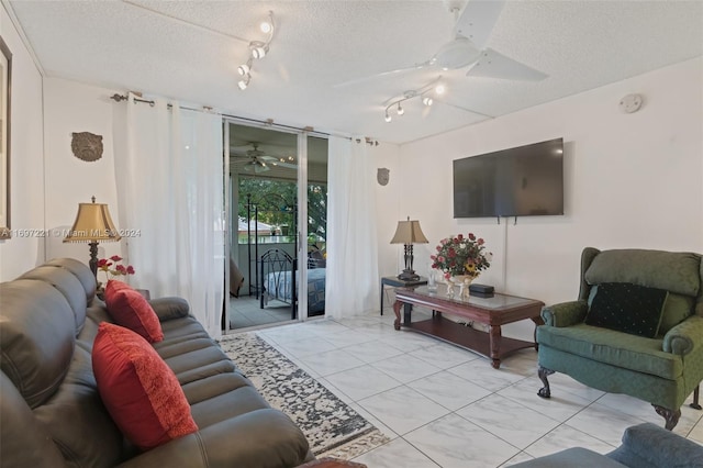 living room with ceiling fan, a textured ceiling, and track lighting