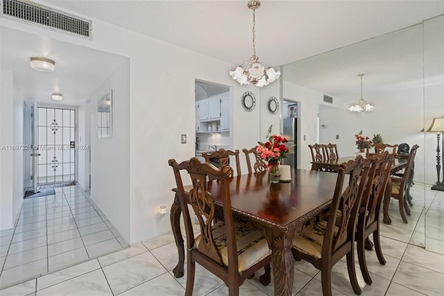 tiled dining space with an inviting chandelier