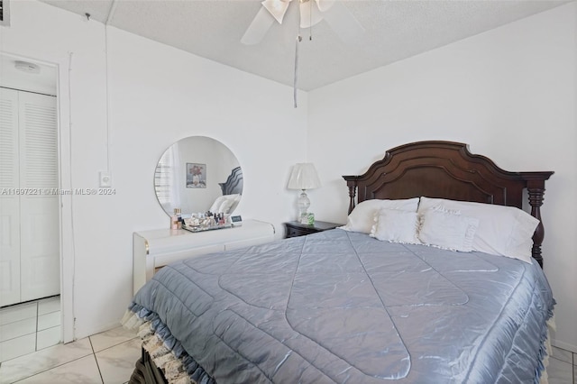 tiled bedroom with a textured ceiling and ceiling fan